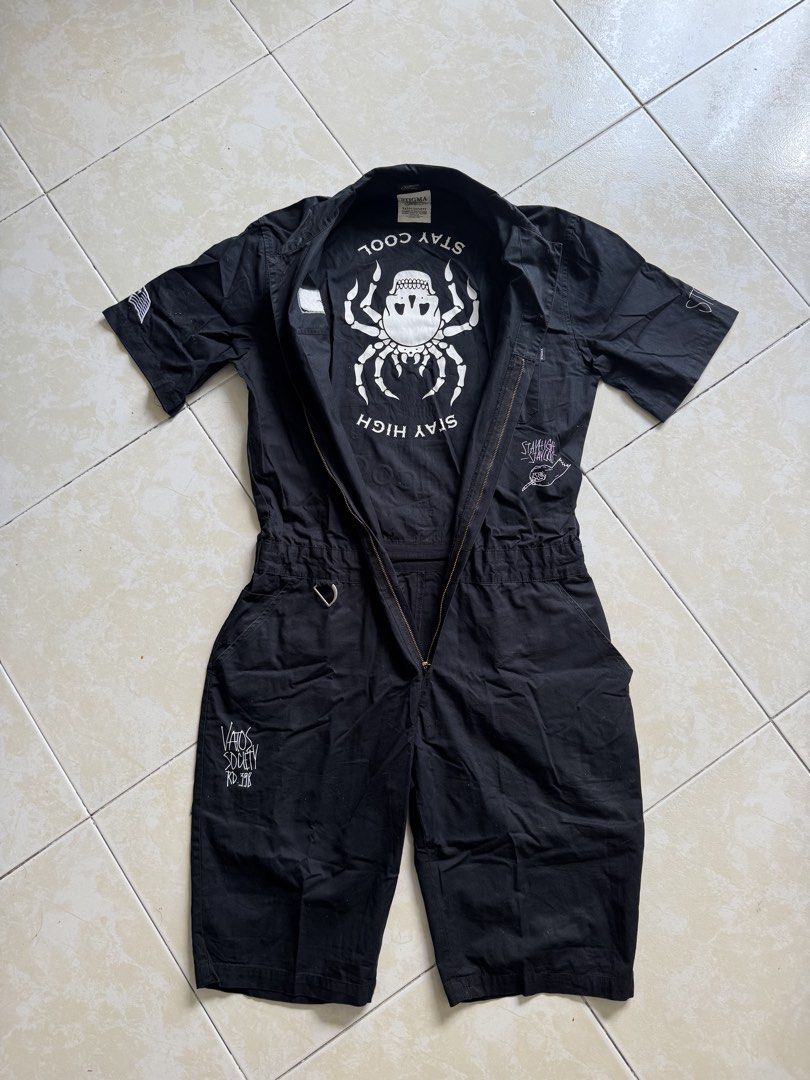 STIGMA Black Short Sleeve Jumpsuit fo Men (Category: Sets & Coordinates) located in Quezon City. Submitted by shndm25 (Listing ID 1424038528, Image 2). Description: - Black short-sleeve jumpsuit - Collared neckline - Front pockets - Zipper closure - Unique graphic prints - Features skull and spider designs - Large skull and wings graphic on the back.