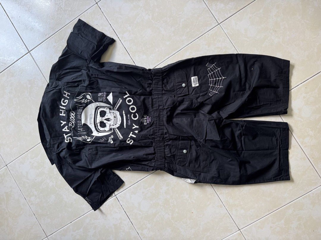 STIGMA Black Short Sleeve Jumpsuit fo Men (Category: Sets & Coordinates) located in Quezon City. Submitted by shndm25 (Listing ID 1424038528, Image 3). Description: - Black short-sleeve jumpsuit - Collared neckline - Front pockets - Zipper closure - Unique graphic prints - Features skull and spider designs - Large skull and wings graphic on the back.