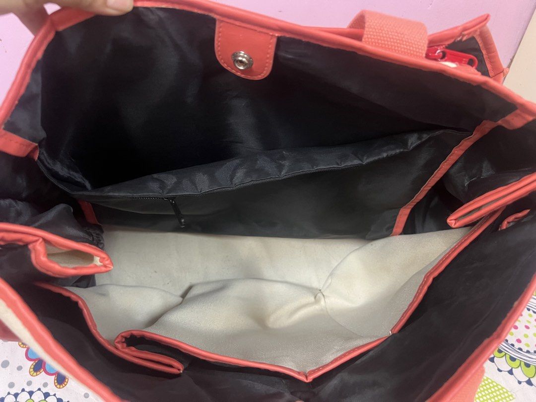 Tennis Themed Tote Bag (Category: Tote Bags) located in Cauayan City . Submitted by mtan15 (Listing ID 1424009534, Image 3). Description: - Tennis-themed tote bag - Cream canvas exterior - Coral-colored handles and trim - Black interior - Main compartment and interior pockets - Button closure - Features crossed rackets and tennis ball design.