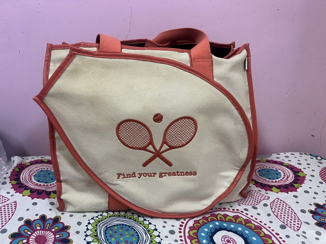 Tennis Themed Tote Bag (Category: Tote Bags) located in Cauayan City . Submitted by mtan15 (Listing ID 1424009534, Image 1). Description: - Tennis-themed tote bag - Cream canvas exterior - Coral-colored handles and trim - Black interior - Main compartment and interior pockets - Button closure - Features crossed rackets and tennis ball design.