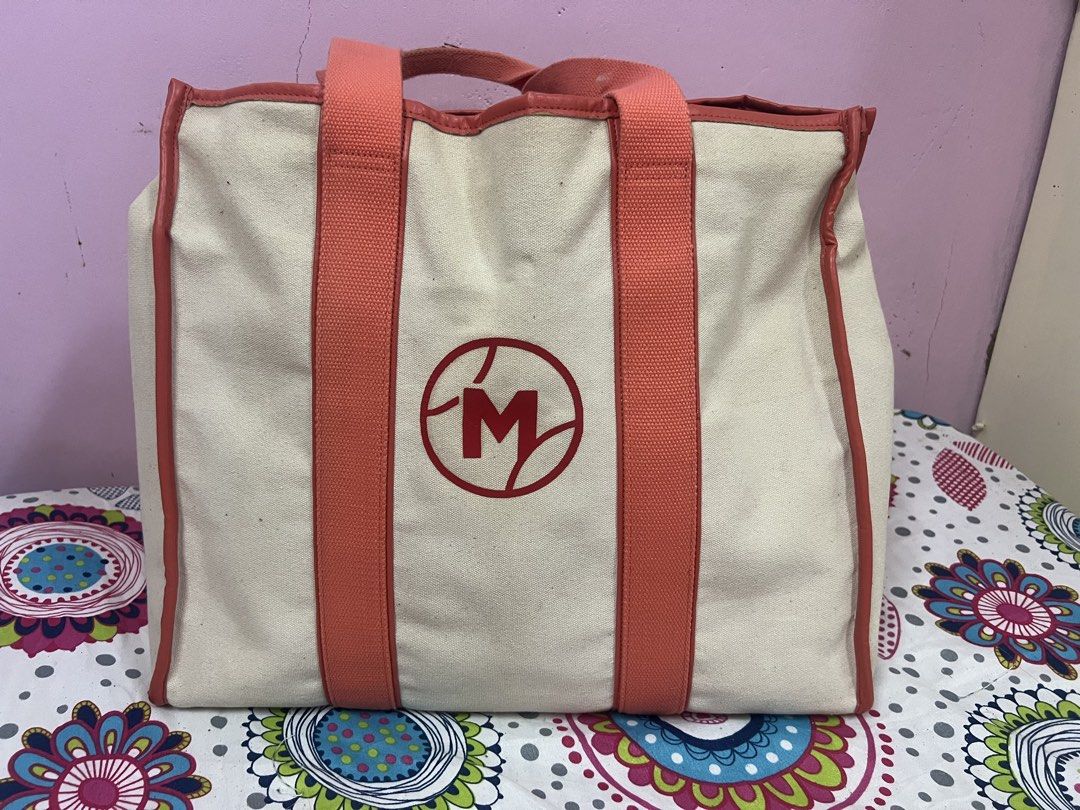 Tennis Themed Tote Bag (Category: Tote Bags) located in Cauayan City . Submitted by mtan15 (Listing ID 1424009534, Image 2). Description: - Tennis-themed tote bag - Cream canvas exterior - Coral-colored handles and trim - Black interior - Main compartment and interior pockets - Button closure - Features crossed rackets and tennis ball design.