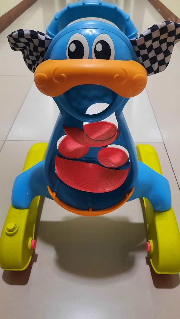 Baby Walker - Blue and Yellow (Category: Infant Playtime) located in Makati City. Submitted by jackstereo777 (Listing ID 1425678177, Image 2). Description: Baby walker features a colorful design with blue, yellow, orange, and red elements. It has a playful face design with a checkered flag detail. The walker has a sturdy base with wheels for easy movement..