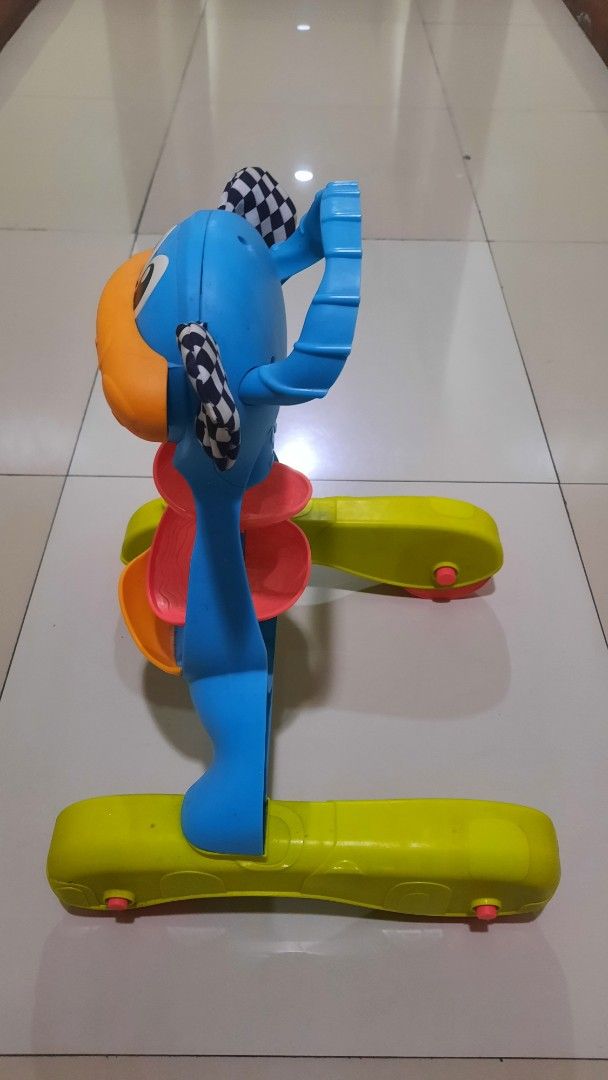 Baby Walker - Blue and Yellow (Category: Infant Playtime) located in Makati City. Submitted by jackstereo777 (Listing ID 1425678177, Image 3). Description: Baby walker features a colorful design with blue, yellow, orange, and red elements. It has a playful face design with a checkered flag detail. The walker has a sturdy base with wheels for easy movement..