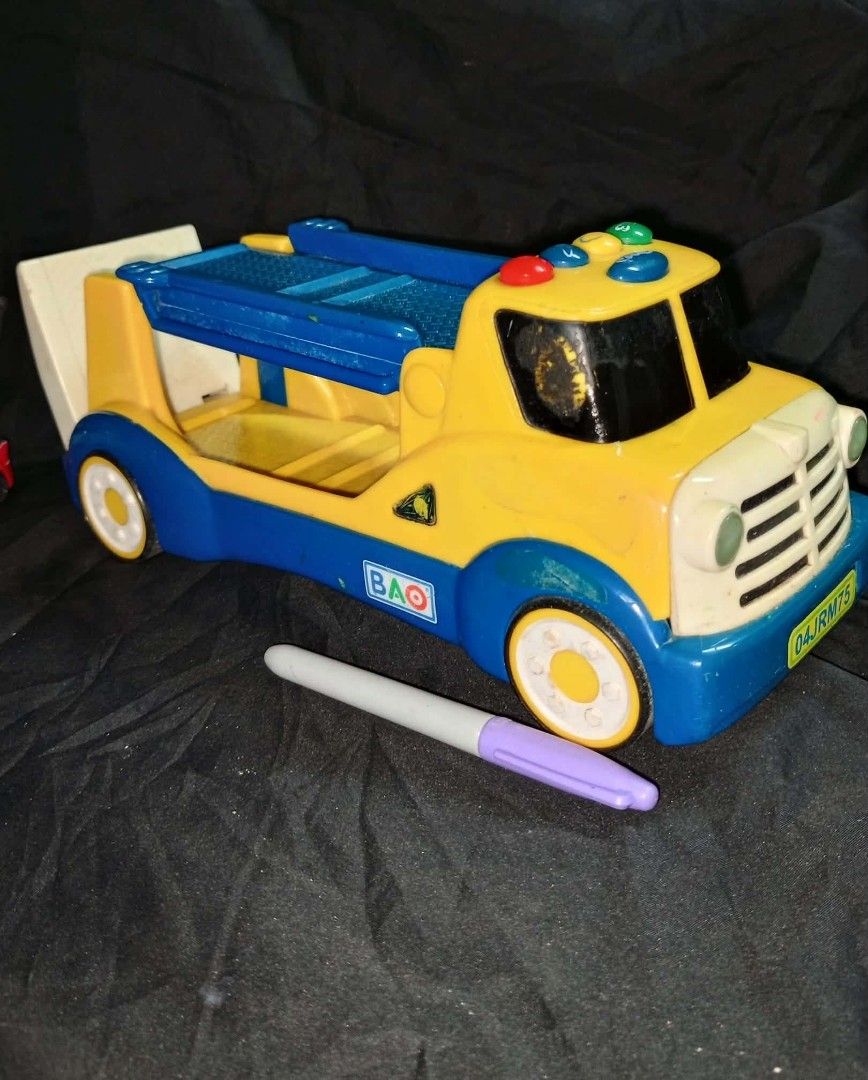 BAO Toy Truck (Category: Vehicle & Diecast Models) located in Kawit. Submitted by monshop714 (Listing ID 1425745659, Image 1). Description: BAO toy truck features a yellow and blue design with a loading bed. It has a cab with lights and a white front. The truck has wheels and a ramp at the back. The battery compartment is visible on the underside. The truck has the brand name "BAO" printed on the side. sound not working.