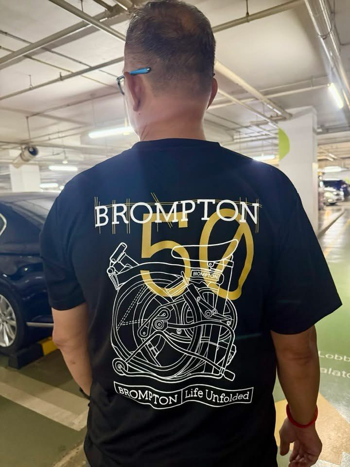 Brompton 50th Anniversary T-Shirt (Category: Parts & Accessories) located in Singapore. Submitted by stellatey23 (Listing ID 1425665658, Image 1). Description: Brompton 50th Anniversary T-shirt. Features a unique design on the back and a small logo on the front. Made of a comfortable, breathable material. Perfect for Brompton enthusiasts or anyone looking for a stylish, commemorative tee. Microfiber dri fit, quick dry fabric material. Size S till