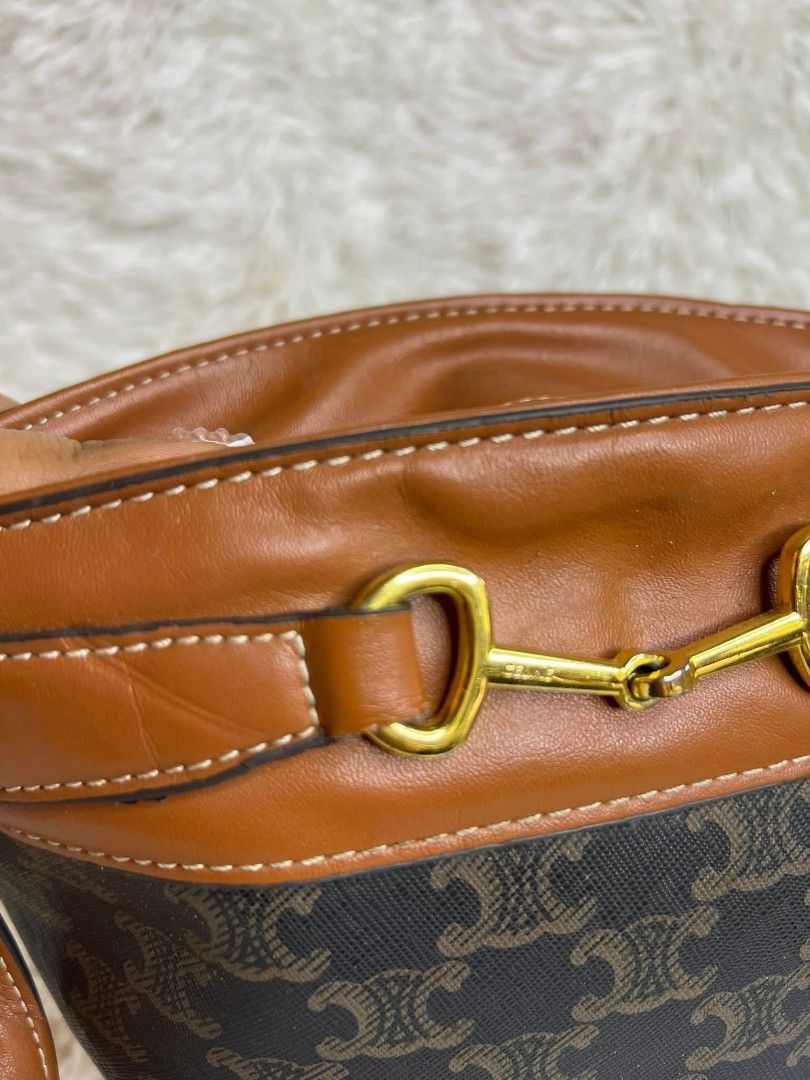Celine Bucket Bag with Shoulder Strap (Category: Luxury Bags & Wallets) located in Manila. Submitted by ricxt (Listing ID 1425633247, Image 3). Description: Celine bucket bag featuring the iconic Triomphe print. It has a brown leather trim and a gold-tone metal detail on the top. The bag comes with a matching brown shoulder strap..