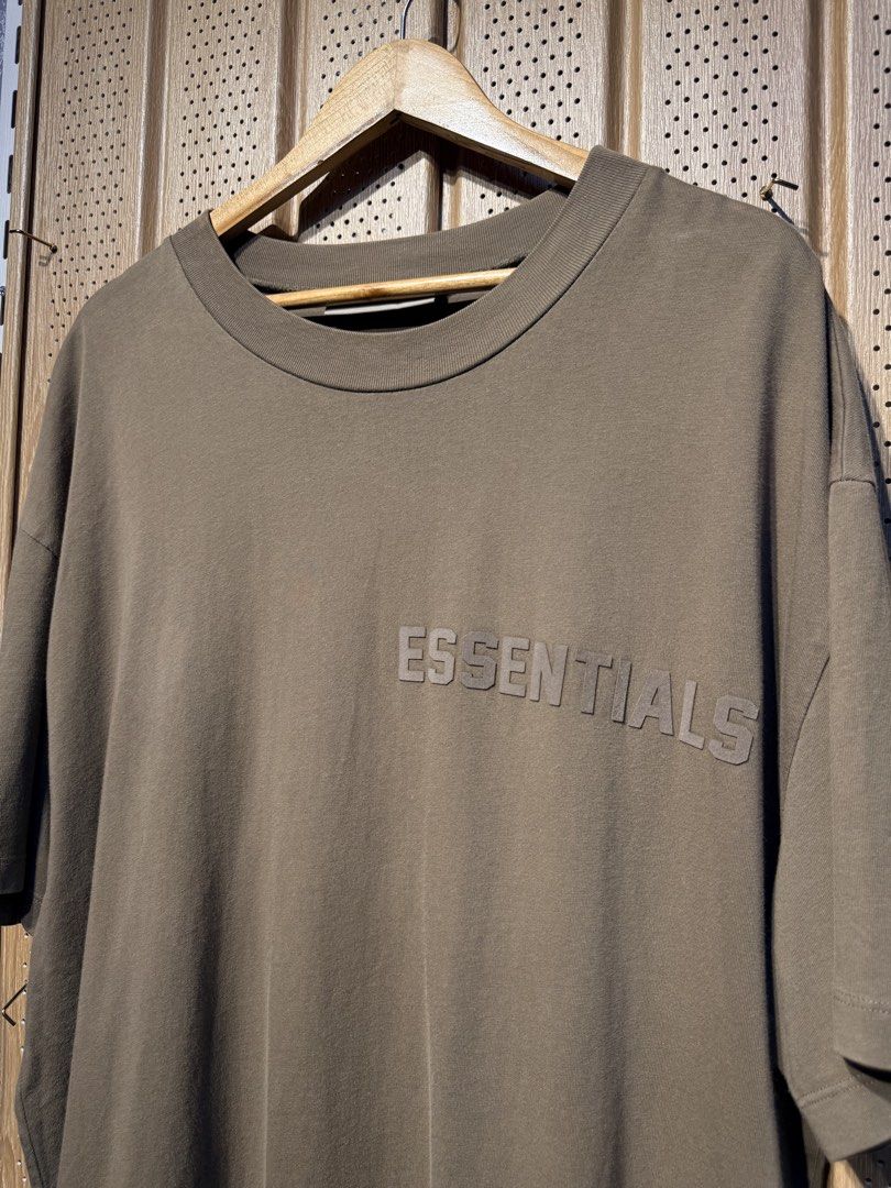 Essentials Fear of God T-shirt XL (Category: Tshirts & Polo Shirts ) located in Santiago. Submitted by twicebutnice03 (Listing ID 1425735900, Image 2). Description: Essentials Fear of God T-shirt is in a brown color. It features the Essentials logo on the front. The size is XL. The tag is visible, confirming the brand and size. Size & dimes: L-XL 24”30.