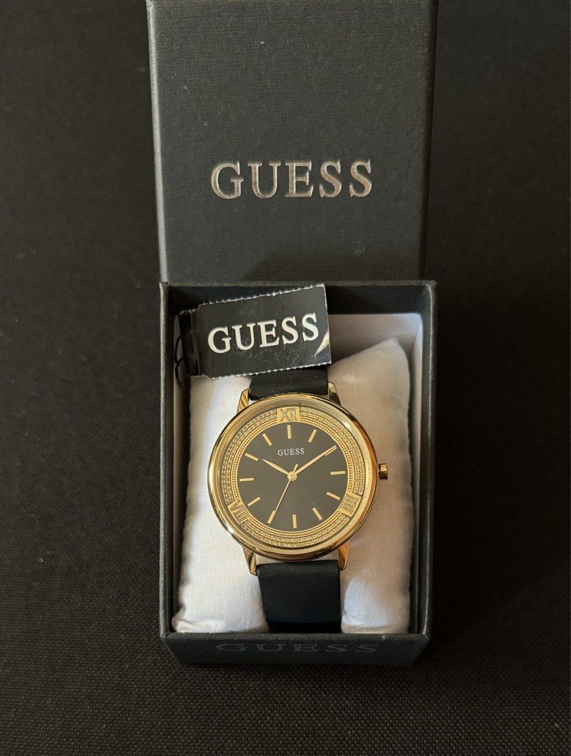Guess Black-Gold Dial Analog Watch (Category: Women's Watches) located in Tarlac. Submitted by iamleeyam (Listing ID 1425821441, Image 2). Description: Guess Black-Gold Analog Watch From the US 🇺🇸 Like new, used once. Key Specifications: Case Size: Approximately 42 mm. Case Material: Gold-tone stainless steel with a crystal-encrusted bezel. Dial: Sleek black analog face with gold-tone markers and hands. Strap: Black silicone band for a blend of