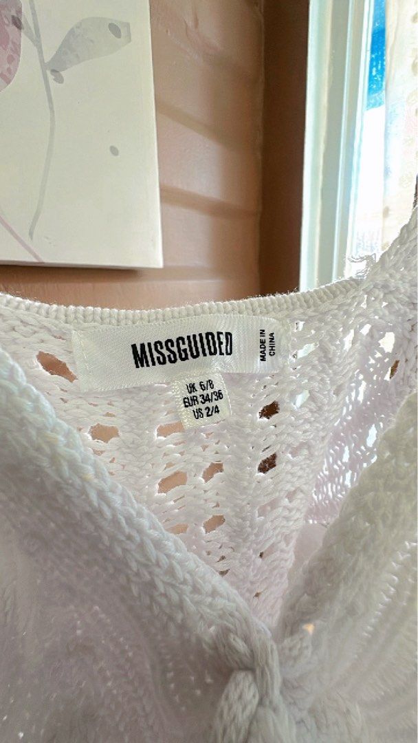 Missguided White Knit Crop Top (Category: Sleeveless) located in Cebu City. Submitted by forless.ph (Listing ID 1425723479, Image 2). Description: White knit crop top from Missguided. Features a V-neckline with a tie detail. The top has a textured knit design and spaghetti straps. Will fit xs to small! Worn twice only.