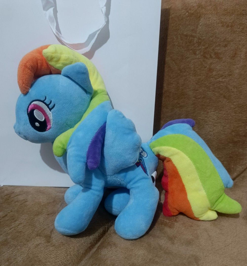 My Little Pony Rainbow Dash Plush Toy (Category: Plushies & Soft Toys) located in Bulacan. Submitted by samotsarihub (Listing ID 1425680666, Image 1). Description: Rainbow Dash plush toy from My Little Pony. It features a blue body, rainbow mane and tail, and the signature cutie mark. The plush is in a sitting position. It is a soft and cuddly toy, perfect for any My Little Pony fan..