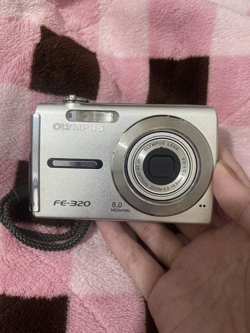 Olympus FE-320 8.0 Megapixel Digital Camera (Category: Cameras) located in Caloocan City. Submitted by blaizeshmn (Listing ID 1425714806, Image 2). Description: Has sensor issue Olympus FE-320 digital camera with 8.0 megapixel resolution. Features an Olympus lens with optical zoom 6.3-18.9mm. Includes a display screen and various function buttons. The camera is silver in color. Made in Indonesia..