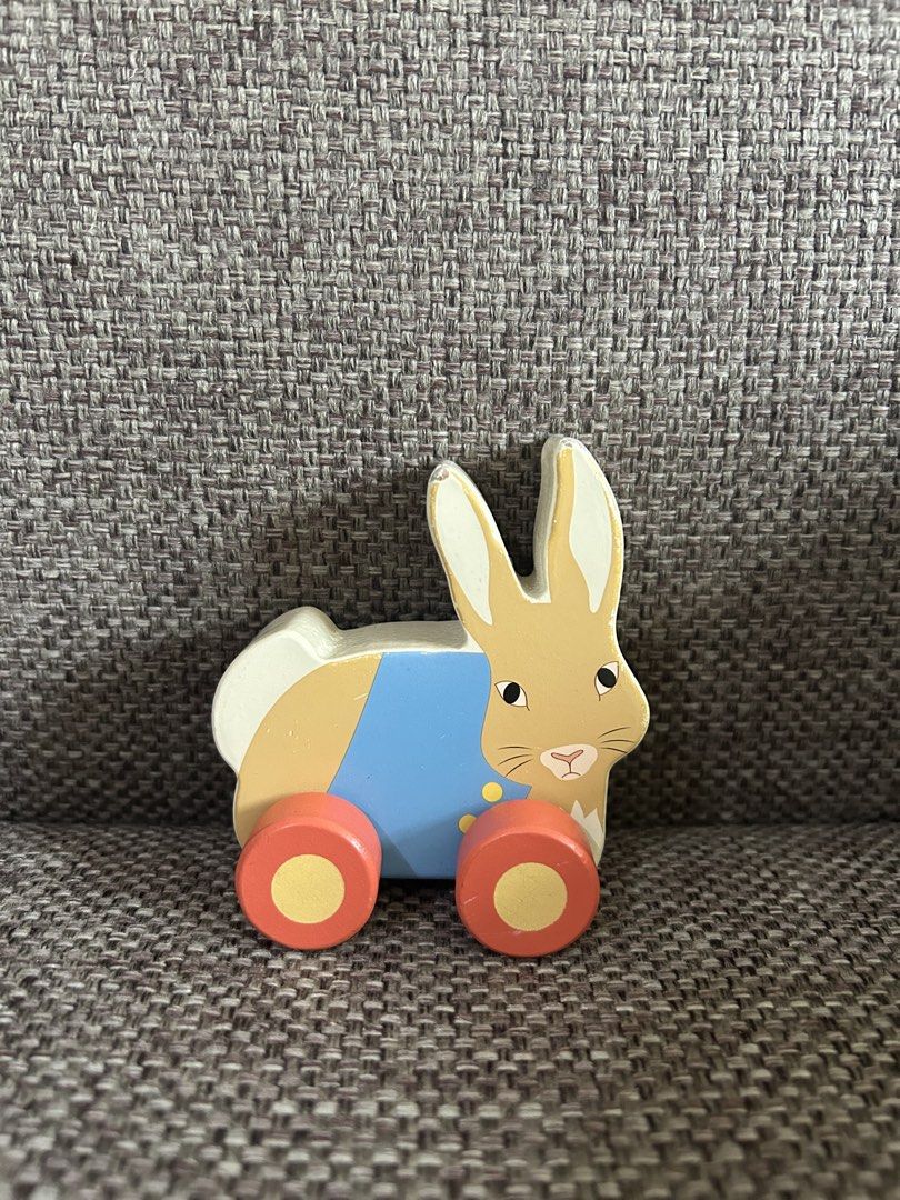 Orange Tree Toys Peter Rabbit Pull Along Toy (Category: Plushies & Soft Toys) located in Marikina City. Submitted by cutesypatsy (Listing ID 1425642187, Image 1). Description: Adorable pull-along toy features Peter Rabbit. It is made by Orange Tree Toys. The toy has a light blue body with orange wheels. The back of the toy has the brand and batch number printed on it. It is a cute and classic toy for young children..