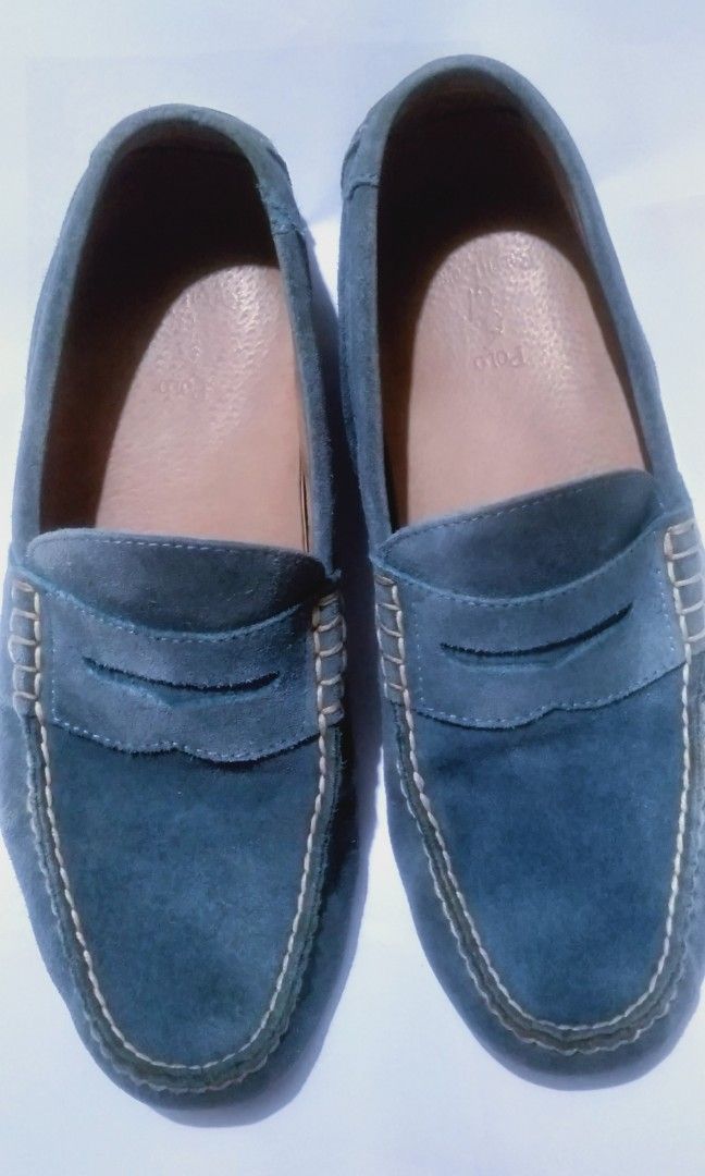 Polo Ralph Lauren Suede Loafers (Category: Dress Shoes) located in Naga. Submitted by pec3c (Listing ID 1425017882, Image 1). Description: These Polo Ralph Lauren loafers feature a suede upper in a blue-grey color. They have a classic penny loafer design with a stitched detail around the top. The insole is a light brown leather, and the Polo logo is visible. The soles show some wear..