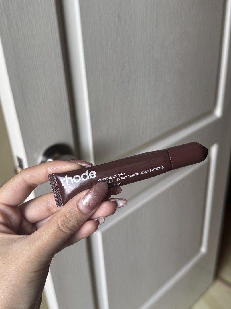 Rhode Peptide Lip Tint - Espresso (Category: Makeup) located in Mandaluyong City. Submitted by goodfindsaf (Listing ID 1425483503, Image 2). Description: Rhode Peptide Lip Tint in Espresso shade. This lip tint provides a touch of color and hydration. The product is 10 ml / 0.3 fl oz. The image shows the product and a swatch of the Espresso color..