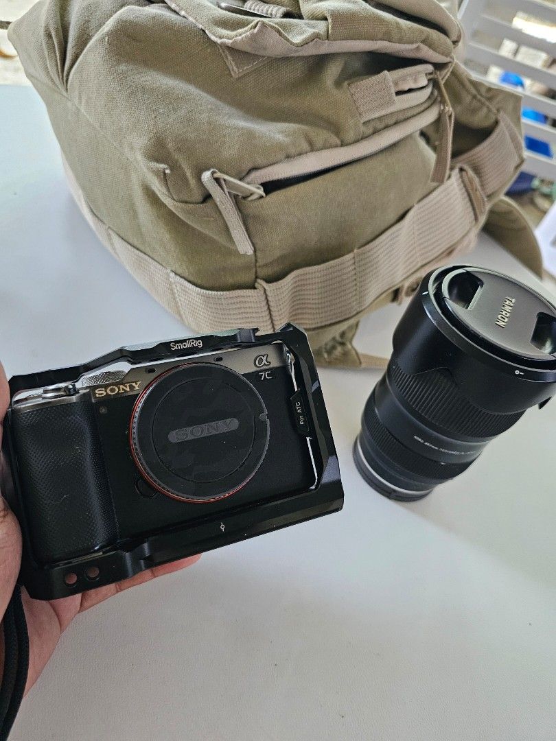Sony Alpha 7C Camera with Tamron 28-75mm Lens (Category: Cameras) located in Quezon City. Submitted by jerome2929 (Listing ID 1425703403, Image 1). Description: Selling a Sony Alpha 7C camera with a Tamron 28-75mm f/2.8 Di III VXD G2 lens. Includes a SmallRig cage for the camera. The lens has a lens hood. The camera has a lens cap. The camera has a strap attached. The camera has a cover on the LCD screen. The camera is black..