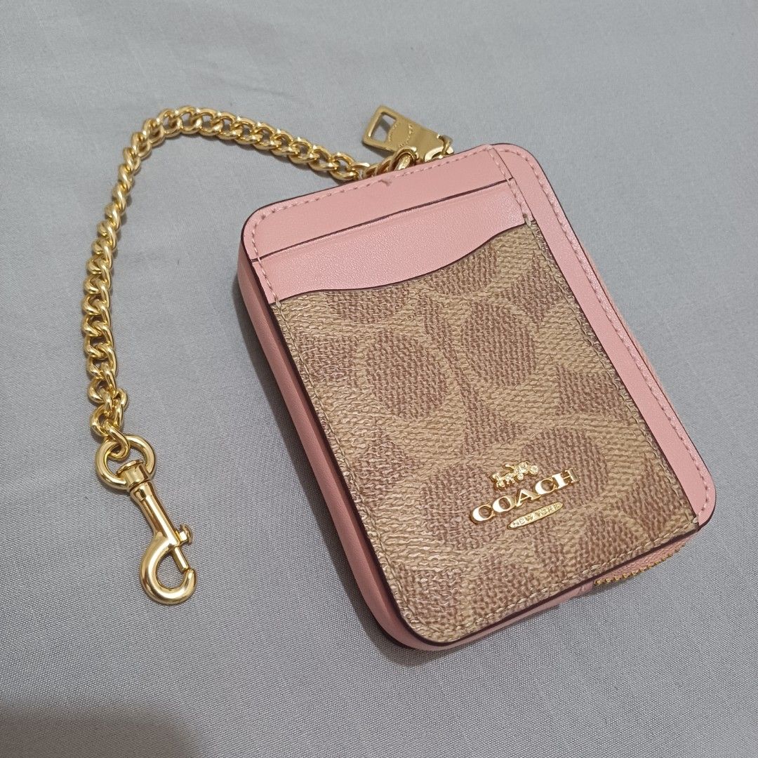 Coach Zip CC S/G Card Holder pink (Category: Luxury Bags & Wallets) located in Paranaque City. Submitted by potatoiceblended (Listing ID 1425920142, Image 1). Description: Coach card holder with a zip closure. Features a signature Coach print with pink accents and a gold chain. Includes card slots and a zip compartment. The tag indicates the style is IM/TAN/PINK PETAL. Made in Cambodia. authentic. i can provide receipt..