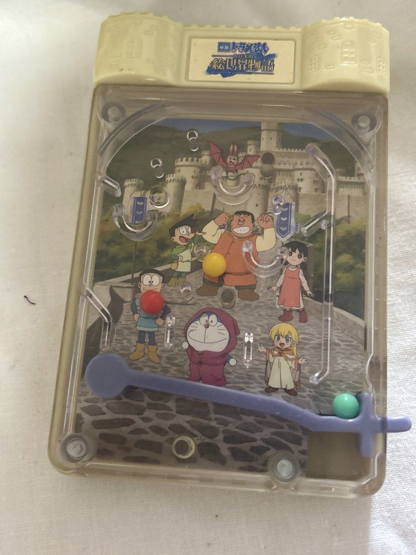 Doraemon Plush Toys and Pinball Game (Category: Plushies & Soft Toys) located in Bulacan. Submitted by ourdailybreads (Listing ID 1425874154, Image 3). Description: Listing includes two Doraemon plush toys and a Doraemon pinball game. One plush toy is a large Doraemon, and the other is a smaller one. The pinball game features Doraemon and other characters. The items are perfect for Doraemon fans and collectors..