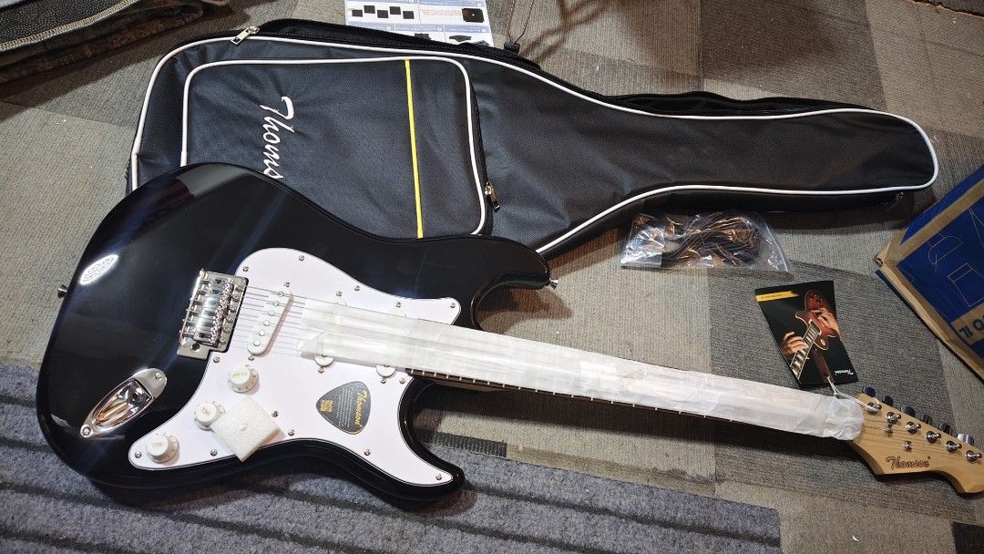 electric guitar Thomson Electric Guitar with Case (Category: Musical Instruments) located in Pasig City. Submitted by tupriomichaeljohn (Listing ID 1425881849, Image 1). Description: Thomson electric guitar with a carrying case. Available in black, sunburst, blue, and brown. Includes a guitar case, cable, and accessories. The guitar has a white pickguard and a maple neck. The headstock has the Thomson logo. Perfect for beginners or experienced pl