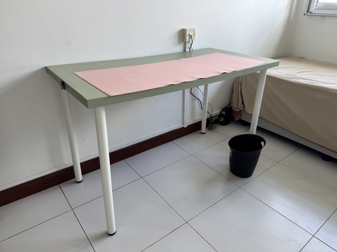 Ikea Study table (Category: Tables & Sets) located in Singapore. Submitted by happy.sylvia (Listing ID 1425940266, Image 1). Description: Green panel with white legs. It is 60 cm (wide), 120 cm (long)*75 cm (height). The pink leather computer mat will be the gift to the buyer. Can pick up at the end of April. .