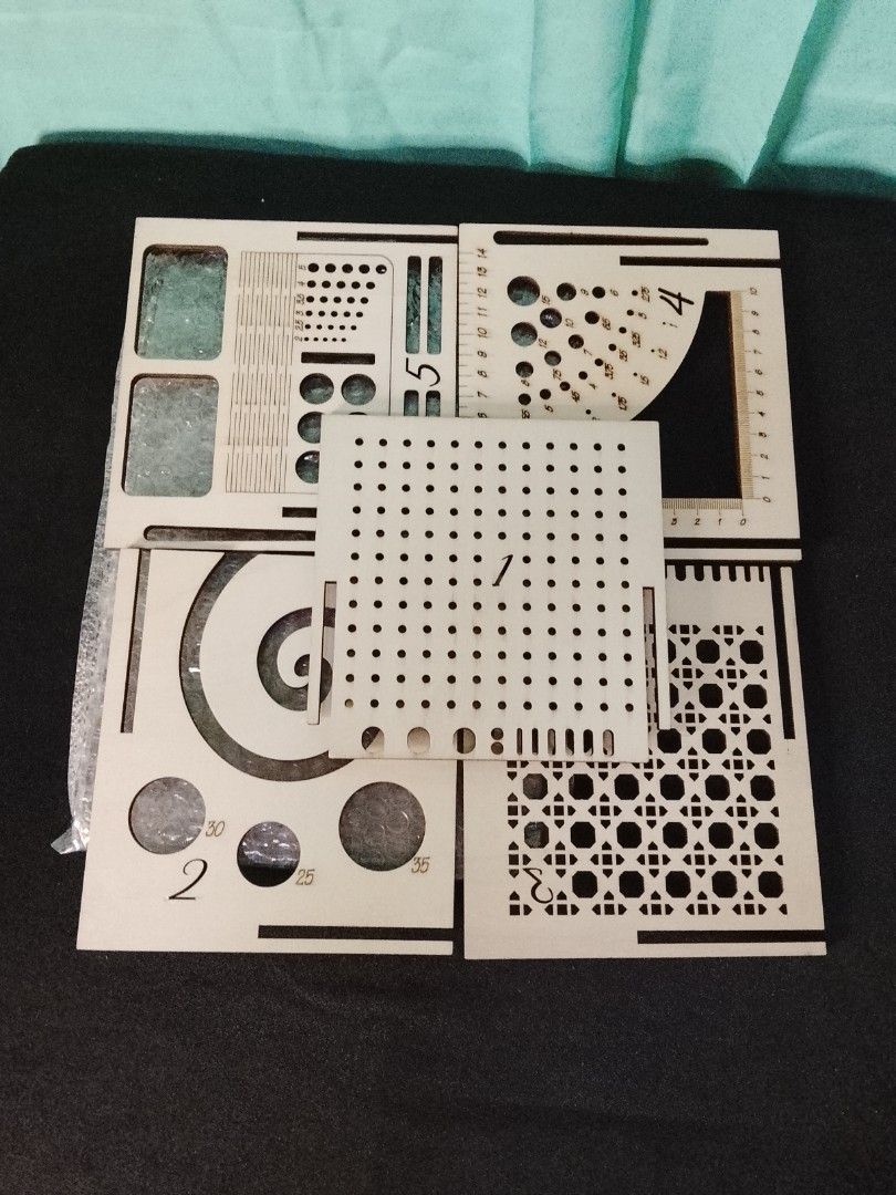Laser Cutting Templates Set (Category: Craft Supplies & Tools) located in Gapan. Submitted by lunashop14 (Listing ID 1426000501, Image 1). Description: Set includes multiple laser cutting templates. It features various shapes, including circles, squares, and patterns. The templates are made of light-colored wood and appear to be unused. They are ideal for crafting and design projects. The set includes templates with different hole sizes and patte