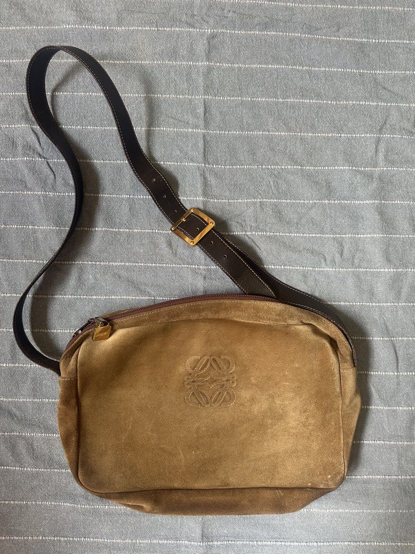 Loewe Suede Shoulder Bag (Category: Luxury Bags & Wallets) located in Mandaluyong City. Submitted by marceditems (Listing ID 1425823628, Image 1). Description: Authentic Loewe shoulder bag crafted from suede. Features a brown leather strap with a gold-tone buckle. The bag has a zip closure and a spacious interior with a Loewe logo. The bag has a classic anagram logo. It has a zip pocket on the back. Major call out are the dirts and corners. .