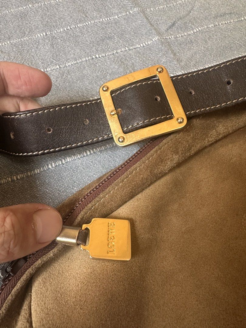 Loewe Suede Shoulder Bag (Category: Luxury Bags & Wallets) located in Mandaluyong City. Submitted by marceditems (Listing ID 1425823628, Image 2). Description: Authentic Loewe shoulder bag crafted from suede. Features a brown leather strap with a gold-tone buckle. The bag has a zip closure and a spacious interior with a Loewe logo. The bag has a classic anagram logo. It has a zip pocket on the back. Major call out are the dirts and corners. .