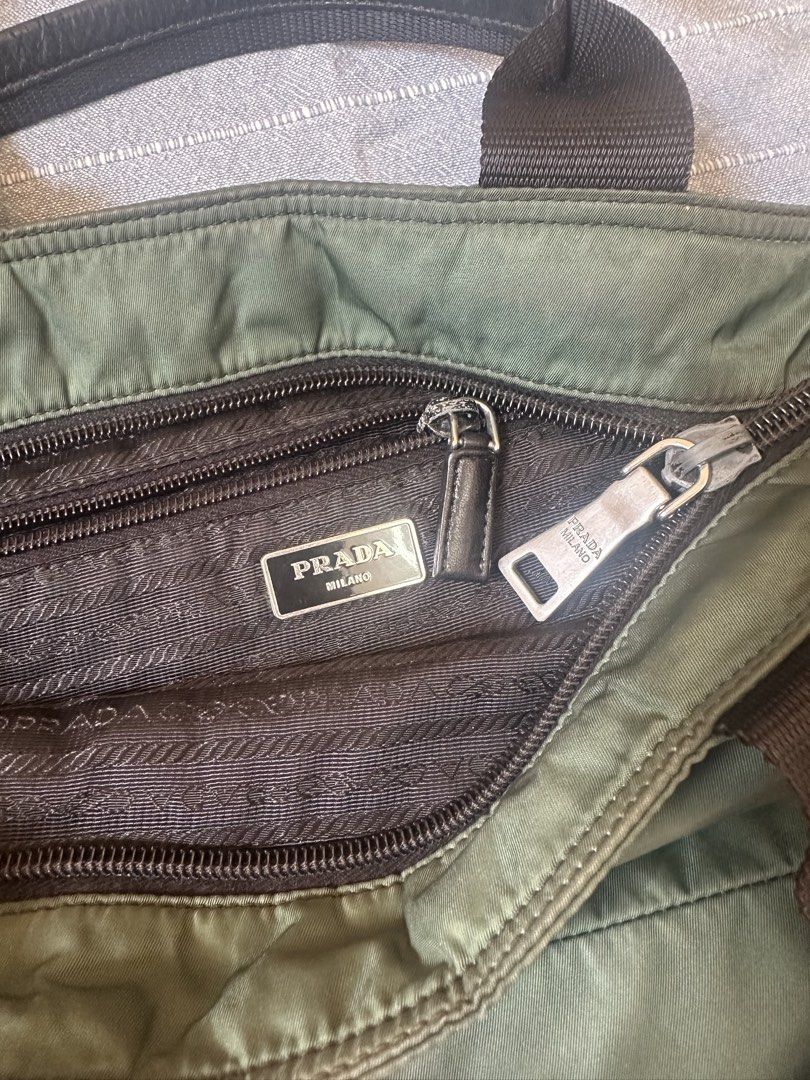 Prada Green Two Way Nylon Bag (Category: Luxury Bags & Wallets) located in Mandaluyong City. Submitted by marceditems (Listing ID 1425825499, Image 3). Description: Authentic Prada two way nylon bag in green. Features a quilted design, top handles, and a detachable long strap. The interior has a Prada Milano label and a zipper closure. Includes a small leather tag and metal hardware with the Prada logo. Made in Italy. Callout is discoloration and