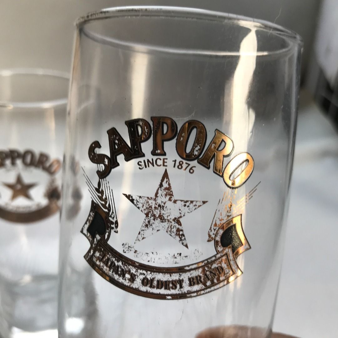Sapporo Beer Glass #4443 (Category: Water Bottles & Tumblers) located in Malabon City. Submitted by mldg.surplus (Listing ID 1425874212, Image 2). Description: Set of two Sapporo beer glasses. Features the Sapporo logo with a star and banner. The glasses are clear and cylindrical. The text "SINCE 1876" and "JAPAN'S OLDEST BRAND" are visible on the glasses. Perfect for enjoying your favorite beer. MLDG Surplus Reminder: •Expect minimal flaws such 