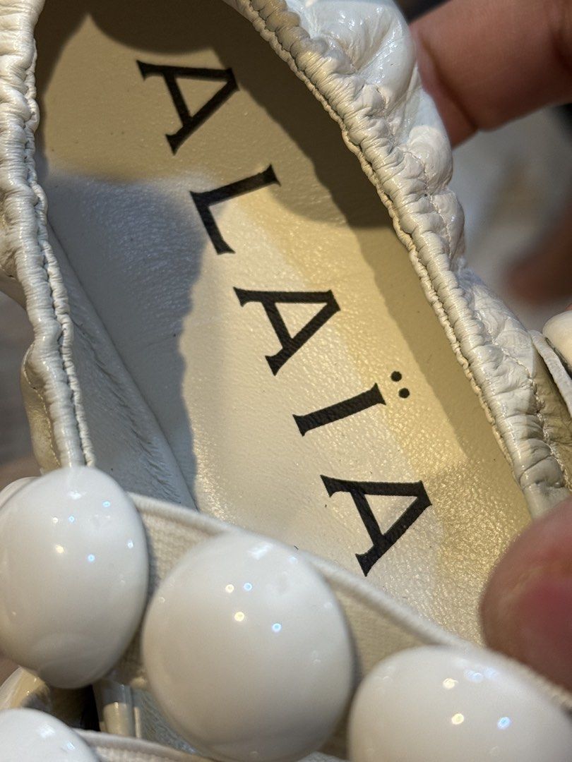 Alaïa White Ballerina Flats Size 36 (Category: Sneakers & Footwear) located in Manila. Submitted by thebodega88 (Listing ID 1426069494, Image 2). Description: Elegant Alaïa ballerina flats in white. Features a unique design with decorative white spheres on the straps. The flats are size 36. The Alaïa logo is visible on the insole and sole. These flats offer a stylish and comfortable fit. NO ISSUE VERY COMFORTABLE PRELOVE CHEAPEST ALAIA IN THE MAR