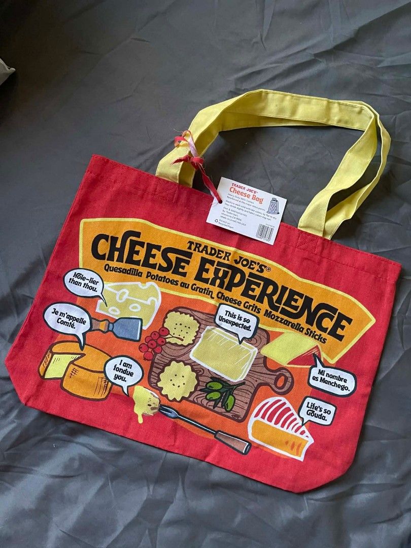 Authentic Trader Joe's "Cheese Adventures" Reusable Tote Bag (Category: Tote Bags) located in Quezon City. Submitted by eejeeberns22 (Listing ID 1426083780, Image 2). Description: * Authentic & Unique * Featuring a vibrant red and yellow design and witty cheese puns, this bag is both functional and fashionable. * Made from durable, heavy-duty 100% cotton canvas * Exclusive Design: Adorned with charming illustrations of grilled cheese, nachos, and