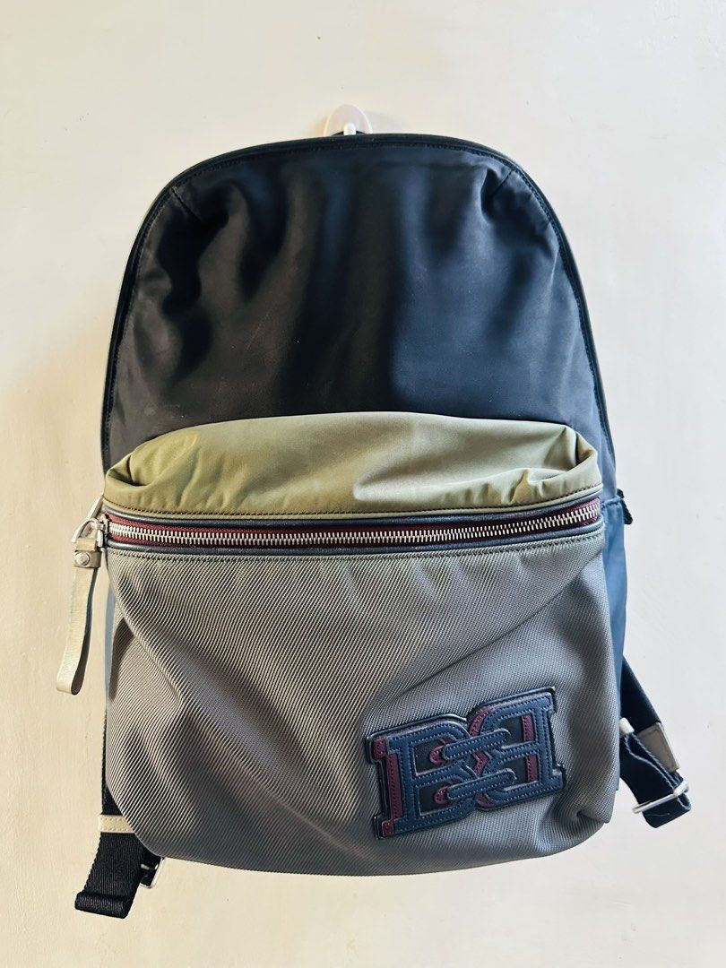 Bally Backpack (Category: Backpacks) located in Subic. Submitted by luxxebrands4less (Listing ID 1426095233, Image 1). Description: - Bally backpack with a multi-tone design - Color scheme: blue, grey, and olive green - Features a front zippered pocket with Bally logo - Adjustable straps for a comfortable fit - Top handle for easy carrying - Main compartment with secure zipper closure.