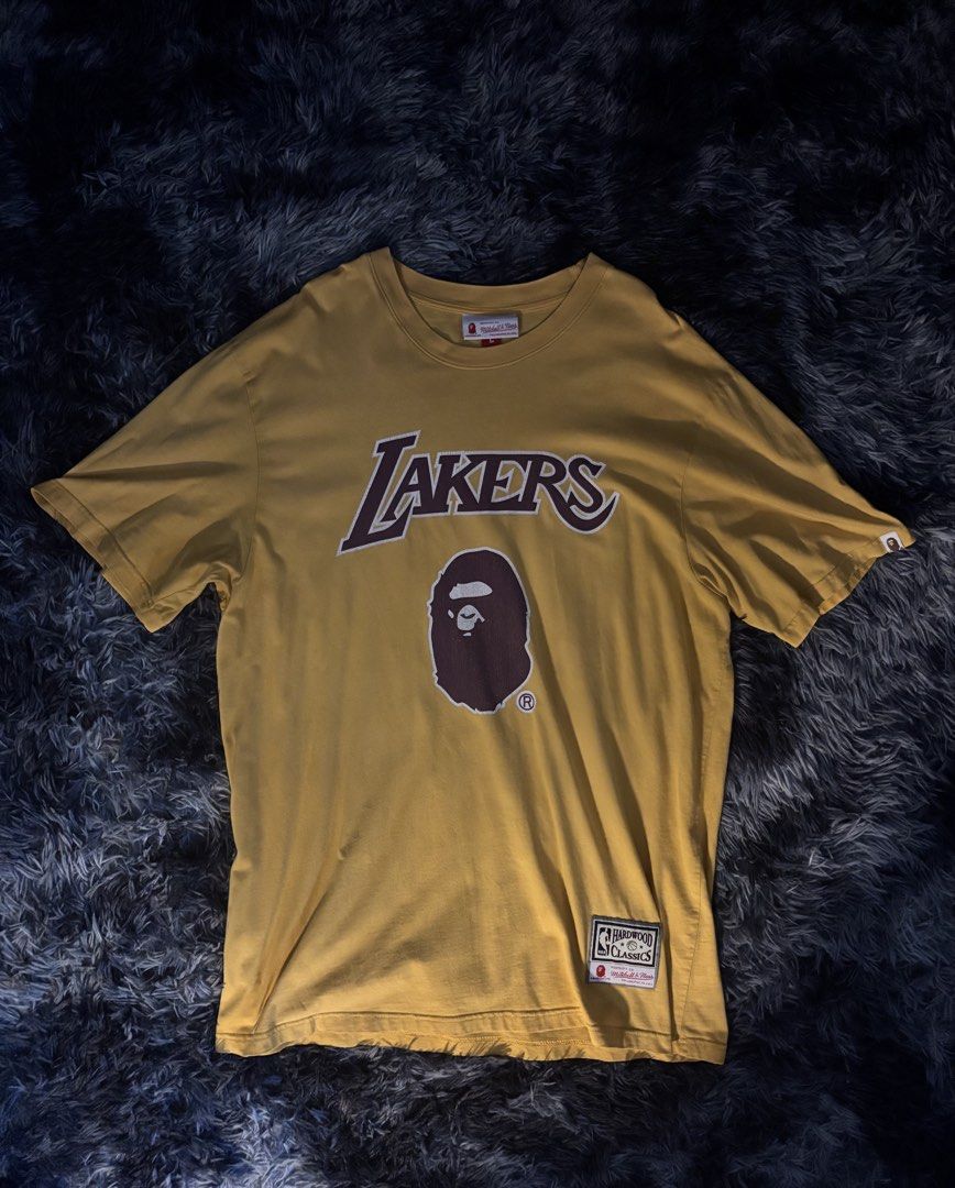 BAPE x Mitchell & Ness Lakers T-shirt (Category: Tshirts & Polo Shirts ) located in Cavite. Submitted by 222.cin (Listing ID 1426181173, Image 1). Description: Size L on tag 24.5x31 Like New NO ISSUE.