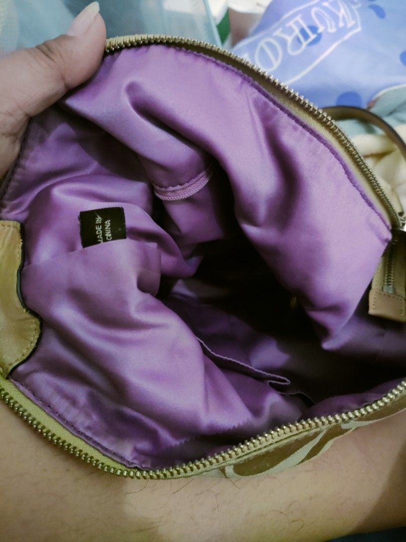 Coach Signature Hobo Bag (Category: Luxury Bags & Wallets) located in Cavite. Submitted by red_2407 (Listing ID 1426181628, Image 2). Description: Coach signature hobo bag in beige. Features a zip closure and a front pocket with a turn-lock closure. The interior is lined with purple fabric and includes a small pocket. The bag has a shoulder strap and a Coach tag inside. Made in China..