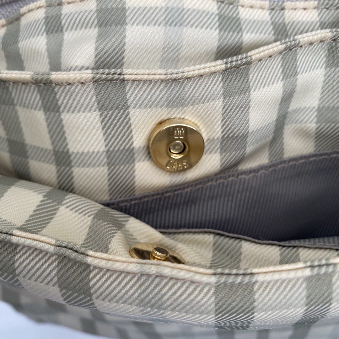 DAKS London Plaid Tote Medium Bag (Category: Tote Bags) located in Roxas City. Submitted by rglnos (Listing ID 1426020078, Image 2). Description: DAKS London tote bag features a classic plaid pattern in neutral tones. It has a top zipper closure and a spacious interior. The bag includes a small interior pocket and a magnetic snap closure. The handles and trim are a matching solid color. The bag has a metal DAKS logo on the front..