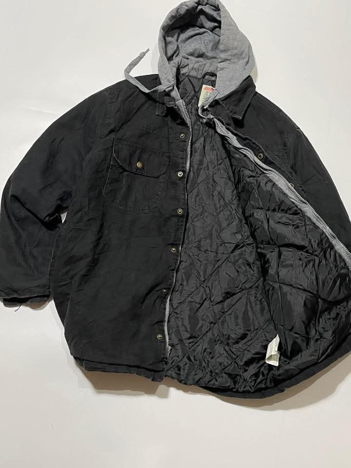 Dickies Hooded Jacket Black (Category: Coats, Jackets and Outerwear) located in Bacoor. Submitted by davealvare39194 (Listing ID 1426071530, Image 2). Description: Black Dickies hooded jacket. Features a gray hood, button-up front, and multiple pockets. The jacket has a quilted lining for added warmth. The size tag indicates a size M/M (38-40)..