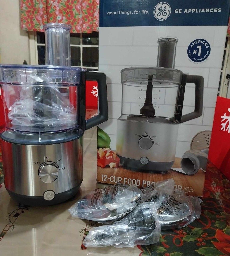 GE 12-Cup Food Processor (Category: Weaning & Toddler Feeding) located in Pasig City. Submitted by rare.ashima25 (Listing ID 1426121876, Image 1). Description: GE food processor is a 12-cup capacity appliance. It comes with multiple blades and attachments, all appearing to be new and unused. The unit has a silver finish and a clear bowl. The box is included. It is designed for various food preparation tasks..