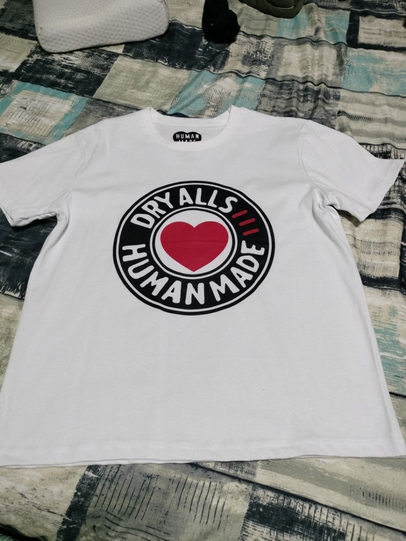 Human Made Heart Logo T-shirt (Category: Tshirts & Polo Shirts ) located in Cavite. Submitted by indigence (Listing ID 1426179296, Image 3). Description: White Human Made T-shirt featuring a heart logo on the front and back. The front design includes the words "DRY ALLS HUMAN MADE" around a red heart. The back has a smaller heart logo with the brand name. It has a crew neck and short sleeves. The size is small. negotiable brand new.