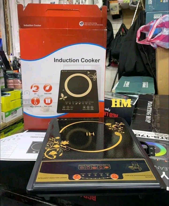 Induction Cooker (Category: Cookers) located in Manila. Submitted by legitseller_angel06 (Listing ID 1426036657, Image 2). Description: Induction cooker features a sleek black design with gold accents. It has multiple cooking settings, including options for hot pot, soup, and frying. The cooker includes a digital display and a power cord. The box indicates it is an "Intelligent Induction Cooker"..