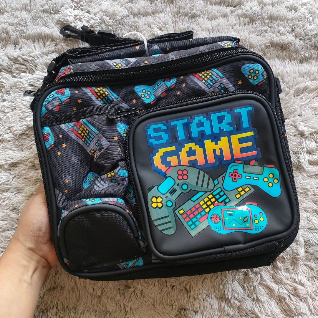 Insulated lunch bag boys (Category: Other Babies Going Out Needs) located in Manila. Submitted by rach0122 (Listing ID 1426183034, Image 1). Description: Lunch bag features a fun gaming theme with controller and keyboard designs. It has multiple compartments, including a front pocket and a main insulated compartment. The bag also has a shoulder strap for easy carrying. Perfect for school or work, it keeps your food fresh and organized..