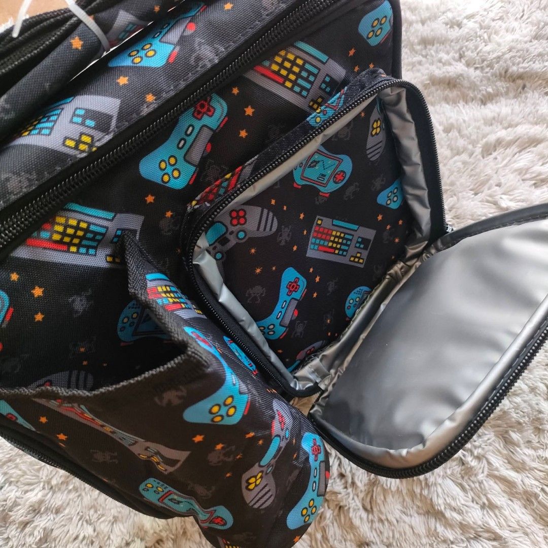 Insulated lunch bag boys (Category: Other Babies Going Out Needs) located in Manila. Submitted by rach0122 (Listing ID 1426183034, Image 3). Description: Lunch bag features a fun gaming theme with controller and keyboard designs. It has multiple compartments, including a front pocket and a main insulated compartment. The bag also has a shoulder strap for easy carrying. Perfect for school or work, it keeps your food fresh and organized..