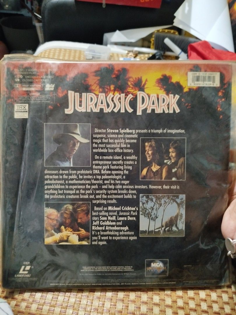 Jurassic Park Laserdisc (Category: CDs & DVDs) located in Subic. Submitted by regiedaniel01 (Listing ID 1426027204, Image 3). Description: Original Jurassic Park Laserdisc. Features the movie title and artwork on the front and back. Includes the original packaging and a video certificate from Singapore. The disc itself is visible inside the packaging. A great collectible for movie enthusiasts..