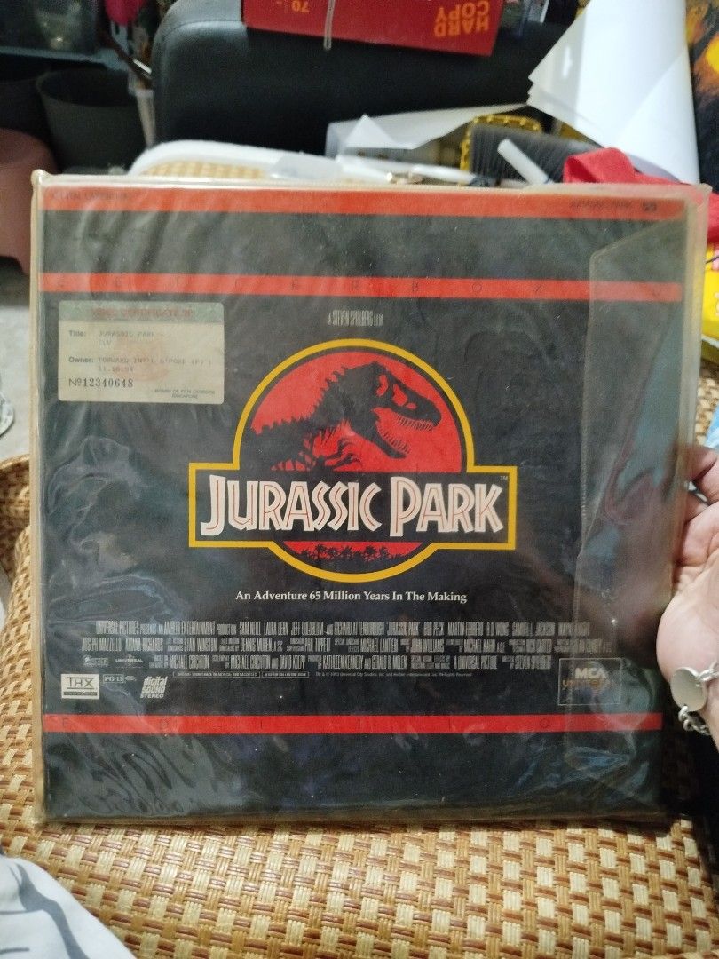 Jurassic Park Laserdisc (Category: CDs & DVDs) located in Subic. Submitted by regiedaniel01 (Listing ID 1426027204, Image 1). Description: Original Jurassic Park Laserdisc. Features the movie title and artwork on the front and back. Includes the original packaging and a video certificate from Singapore. The disc itself is visible inside the packaging. A great collectible for movie enthusiasts..