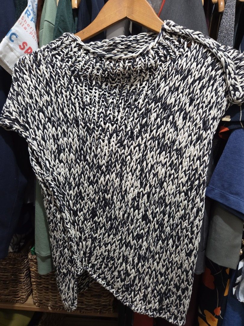Knitted Sweater - Black and White (Category: Coats, Jackets and Outerwear) located in Antipolo. Submitted by droldee (Listing ID 1426128425, Image 1). Description: Knitted sweater features a unique black and white pattern. It has a round neckline and a sleeveless design. It is a versatile piece that can be paired with various outfits. The sweater is displayed on a wooden hanger..