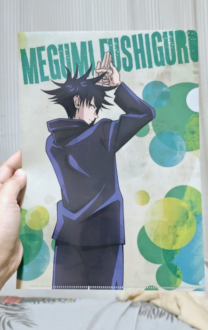 Megumi Fushiguro File Folder (Category: Stationery & School Supplies) located in Manila. Submitted by yourfavoritethings7 (Listing ID 1426021839, Image 1). Description: File folder features Megumi Fushiguro from Jujutsu Kaisen. The design includes an illustration of Megumi with his name printed in green. The background has a pattern of colorful circles..