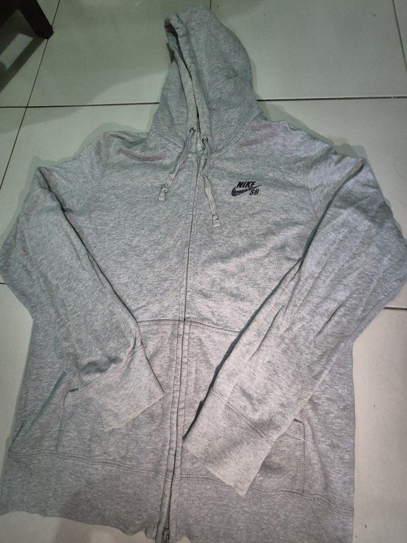 Nike SB Zip-Up Hoodie (Category: Hoodies) located in Manila. Submitted by rochrens (Listing ID 1426025155, Image 1). Description: Gray Nike SB zip-up hoodie. Features a hood with drawstrings and a Nike SB logo on the chest. Includes two front pockets. From the athletic dept Unisex Fits small to med Men Fits Large to Women.