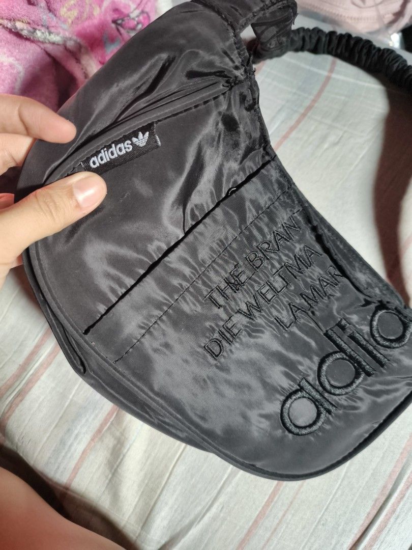 Original Adidas Black Kili Bag (Category: Shoulder Bags) located in Manila. Submitted by kitty.ribbon (Listing ID 1425998229, Image 2). Description: Black Adidas shoulder bag. Features a braided strap and a small Adidas logo charm. The bag has the Adidas logo embossed on the front. The bag has a curved shape..