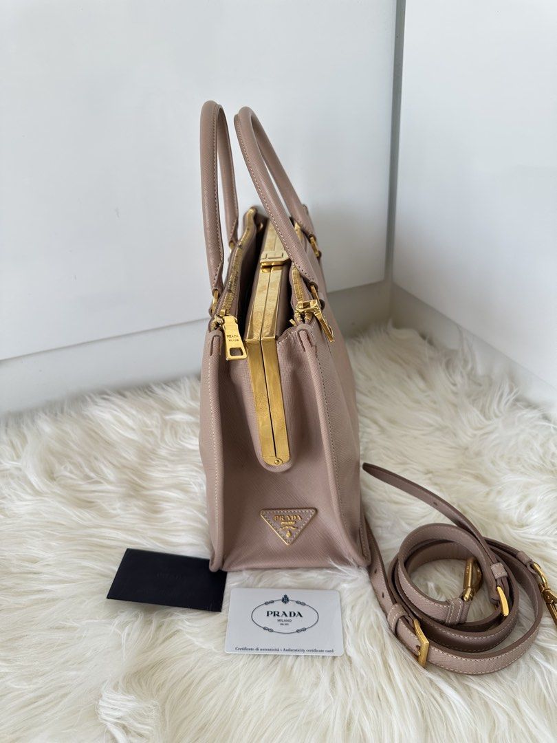Prada Saffiano Lux Cammeo (Category: Luxury Bags & Wallets) located in Cabanatuan. Submitted by matetqqq (Listing ID 1426097111, Image 3). Description: Prada Saffiano Lux Frame Bag features a beautiful blush pink color with gold-tone hardware. It includes a detachable shoulder strap and a frame closure. The bag comes with authenticity cards. The bag has a structured shape and a classic design..