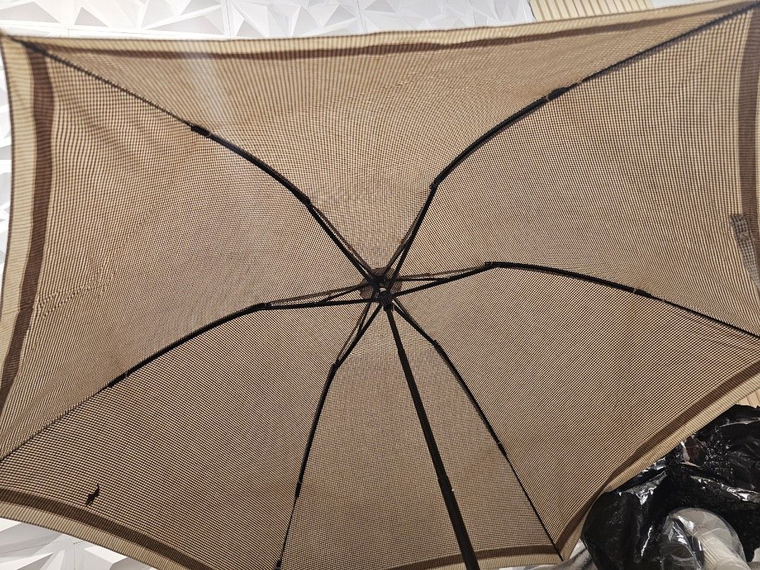 Ralph Lauren Umbrella (Category: Umbrellas) located in Tabuk. Submitted by northern_luxury (Listing ID 1426005537, Image 3). Description: Ralph Lauren umbrella features a tan and brown checkered pattern. The handle is made of wood with a gold-colored band that has the brand name. The umbrella has a classic design with a sturdy frame. It is a stylish accessory for sun or rain. nasa pic po ang flaw. it comes with a case.