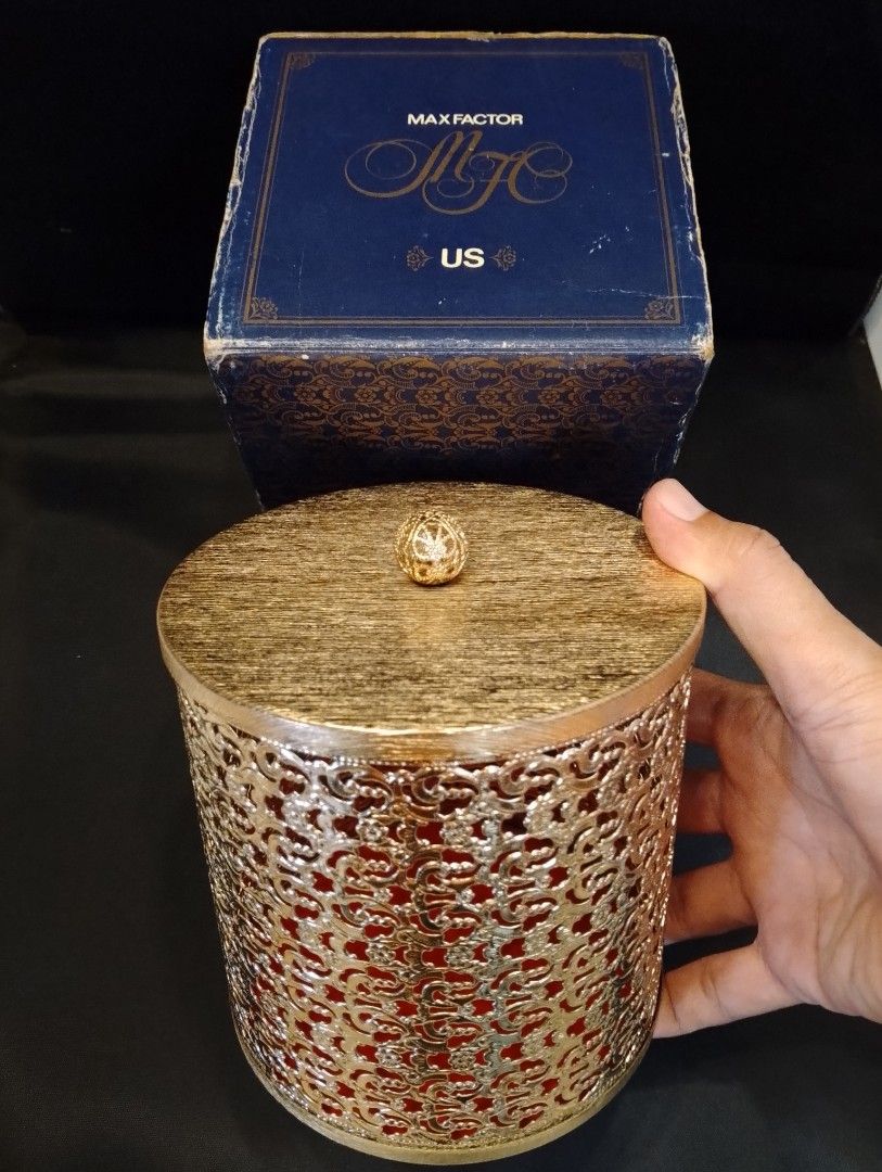 Vintage Max Factor Cosmetic Gold Container with Box (Category: Makeup) located in Binangonan. Submitted by stufflikedat (Listing ID 1426101108, Image 2). Description: Vintage Max Factor (US} gold-toned filigree decorative all metal container with a lid cover, red felt base interior and original box often styled as trinket box, canister or vanity decor in shiny new old stock & unused condition approx 5"height x 5" diameter for 750 + shipping.