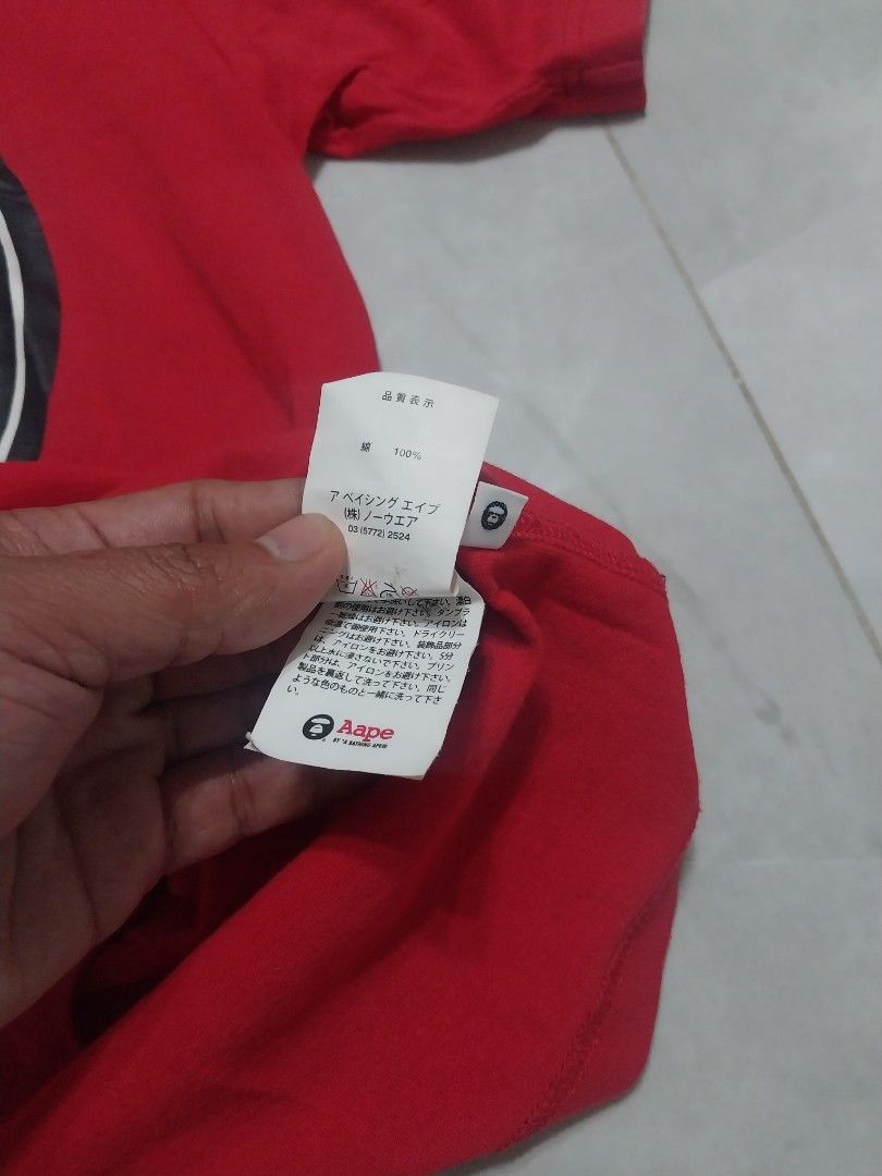 Aape by A Bathing Ape Red T-shirt (Category: Tshirts & Polo Shirts ) located in Malaybalay. Submitted by markdaumar08466 (Listing ID 1426301519, Image 3). Description: Authentic Aape by A Bathing Ape red t-shirt. Features a large graphic on the front with the text "IN THE AAPE UNIVERSE SOMEWHERE IN AAPE". The shirt has a small Aape logo on the sleeve. The tag indicates the shirt is made of 100% cotton..